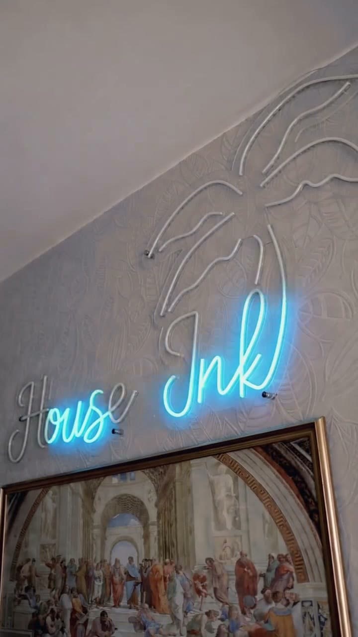 Duvardaki neon palmiyeli House Ink tabelası